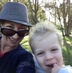 eonie and a child smiling together outdoors in a park setting.